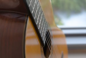 brown acoustic guitar in close up photography