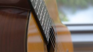 brown acoustic guitar in close up photography