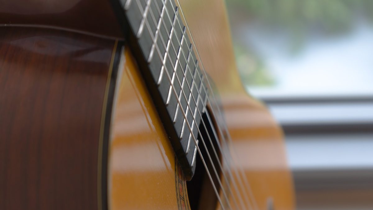 brown acoustic guitar in close up photography