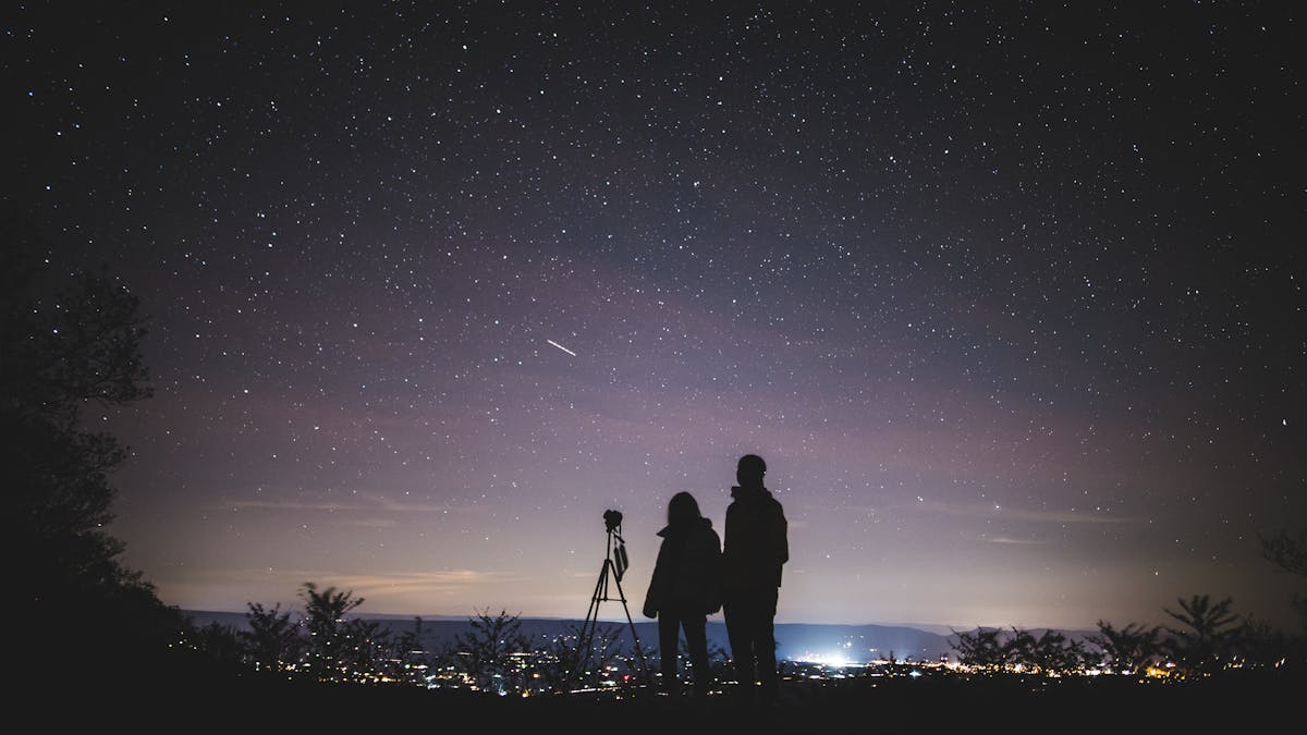 Silhouette of Two Persons Stargazing