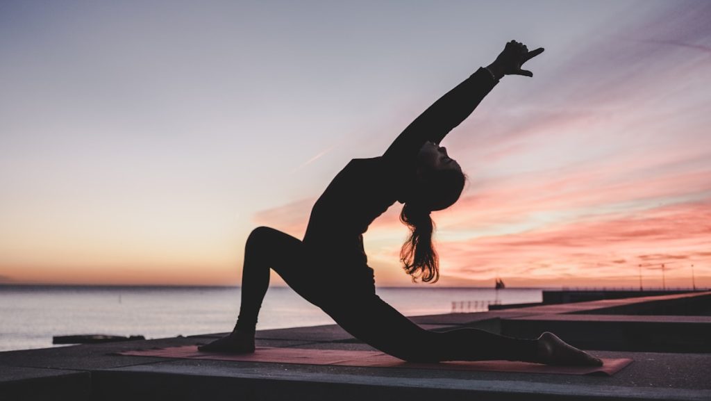 silhouette of woman doing yoga