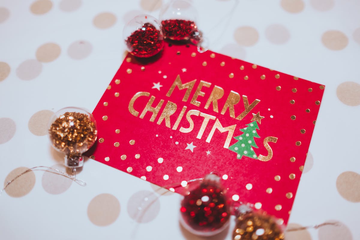 A vibrant red Merry Christmas card surrounded by festive glitter ornaments, perfect for holiday celebrations.